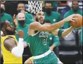  ?? Associated Press ?? The Celtics’ Jayson Tatum (0) goes up to shoot against the Lakers’ LeBron James (left) during the first half on Friday in Boston. The Celtics beat the Lakers in James’ return.