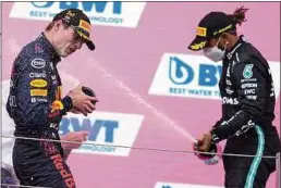  ??  ?? Champagner­dusche der Rivalen Max Verstappen (l.) und Lewis Hamilton.