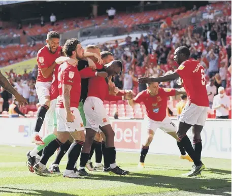  ??  ?? Carlos Mendes Gomes of Morecambe celebrates with teammates after securing promotion to League One at Wembley.