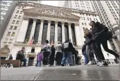  ?? Peter Morgan Associated Press ?? PEOPLE WALK past the New York Stock Exchange on Wednesday. The S&P 500 climbed 0.9% to 5,248.49.