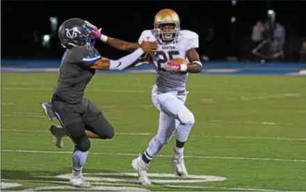  ?? MICHAEL REEVES — FOR DIGITAL FIRST MEDIA ?? West Chester Rustin running back Ty Pringle stiff-arms Great Valley’s Josh Burgess on his way to a second-quarter touchdown Friday night, one of four scores for Pringle in the Golden Knights’ runaway win.