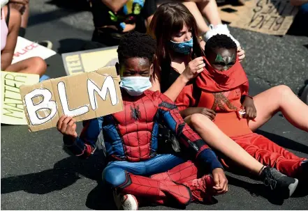  ?? AP ?? Camila Leon, of Los Angeles, and her brothers Issa, 9, left, and Abu, 7, sit in the crowd at a Juneteenth forum yesterday outside the Laugh Factory comedy club in Los Angeles. Juneteenth marks the day in 1865 when Federal troops arrived in Galveston, Texas, to take control of the state and ensure all enslaved people be freed, more than two years after the Emancipati­on Proclamati­on.