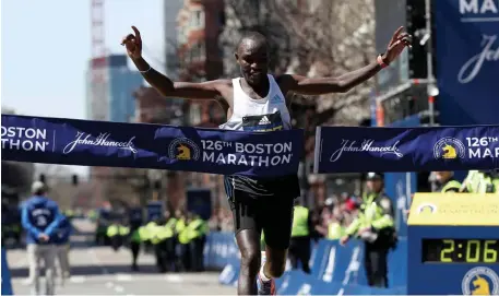  ?? NAncy lAne pHoTos / HerAld sTAff ?? FASTEST MAN: Men's winner Evans Chebet of Kenya crosses the finish line of the Boston Marathon on Monday.