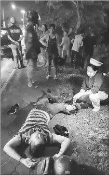  ??  ?? A nurse attends to the injured motorcycli­st at the scene of the accident.