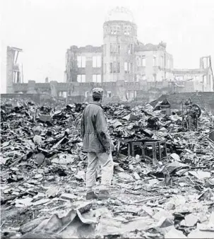  ?? STANLEY TROUTMAN/AP ?? SEPT. 8, 1945: A war correspond­ent stands in the rubble in front of what was once a movie theater in Hiroshima, a month after the bombing.