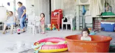  ??  ?? •La pequeña Valentina se refresca en una tina durante el apagón.