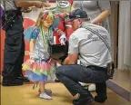  ??  ?? Harper McDonald,
5, of Lake Worth, a Palms West patient dressed as My Little Pony’s Rainbow Dash, gets some candy Tuesday from Palm Beach County Fire Rescue’s Mitchell Longley.