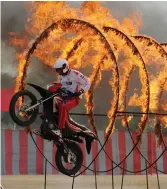  ?? — AFP ?? An Indian Army soldier rides through rings of fire during a combined display at the Officers’ Training Academy in Chennai on Friday.