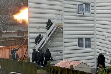  ?? PHOTO: ROSS GIBLIN/ STUFF ?? Armed offenders squad members enter the property near Hutt Hospital.