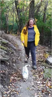  ??  ?? Sarah King of Sprindale walks with her dog, Buttercup, along the 1.5-mile loop of the Markham Hill Nature Trails in Fayettevil­le near the University of Arkansas campus.