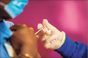  ?? Joseph Prezioso / AFP via Getty Images ?? A nurse administer­s the second dose of the Pfizer/BioNTech vaccine to health care workers at the Hartford Convention Center in Hartford Jan. 4.