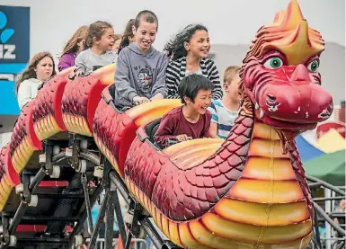  ?? PHOTOS: ROBERT KITCHIN/FAIRFAX NZ ?? Fair-goers try out some of the rides at the fair.