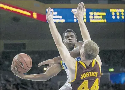  ?? Robert Gauthier Los Angeles Times ?? UCLA’S AARON HOLIDAY gives himself a little elbow room to maneuver against Arizona State’s Kodi Justice during the first half at Pauley Pavilion. Holiday scored 13 points, making three of five three-pointers, and had eight assists in the Bruins’ victory.