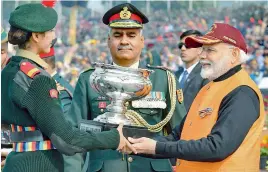  ?? PTI ?? Prime Minister Narendra Modi presents a trophy to the winner during the Annual PM’s National Cadet Corps (NCC) Rally 2020, in New Delhi on Tuesday. —