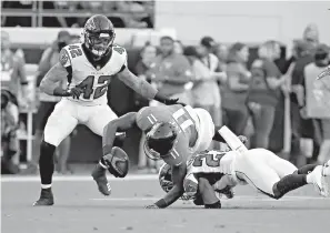  ?? AP Photo/Stephen B. Morton ?? ■ Jacksonvil­le Jaguars wide receiver Marqise Lee (11) is injured as he is tackled by Atlanta Falcons cornerback Damontae Kazee, right, and linebacker Duke Riley (42) during the first half Saturday in Jacksonvil­le, Fla. Lee was taken off the field on an medical cart after the play.