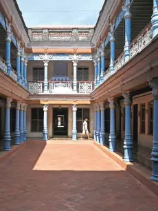  ?? ?? A man walks through a courtyard at the Chettinadu Mansion in Kanadukath­an town in India’s Tamil Nadu state.