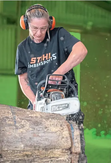  ?? ?? Catherine Eccles takes a chainsaw to the timber as she practises wood chopping and, inset below, showing her skills with axe