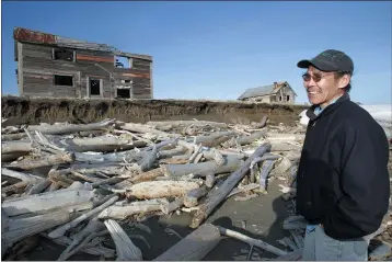  ?? AL GRILLO — THE ASSOCIATED PRESS FILE ?? Simon Bekoalok stands where the eroding land was when he was a child growning up in the now abandoned village of Shaktoolik, Alaska.