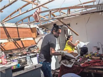  ?? DOROTHY EDWARDS, USA TODAY NETWORK ?? Leticia Magana cleans out her trailer with her son Luis Ladrillero­s on Monday, the morning after Hurricane Irma and its winds of up to 130 mph ripped off her roof in Immokalee, Fla.