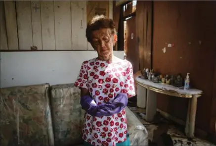  ?? MARIO TAMA, GETTY IMAGES ?? Sonia Torres stands while posing in her destroyed home while taking a break from cleaning, three weeks after Hurricane Maria hit the island, in Aibonito, Puerto Rico. The area is without running water or grid power as a nightly curfew remains in effect.