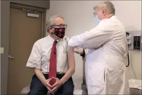  ?? OHIO GOVERNOR’S OFFICE VIA AP ?? Ohio Gov. Mike DeWine, left, gets his first dose of the COVID-19vaccine from Dr. Kevin Sharrett, Feb. 2, , in Jamestown, Ohio. Dewine became eligible to receive his first shot this week as vaccinatio­ns are now open to Ohioans age 70 and above.