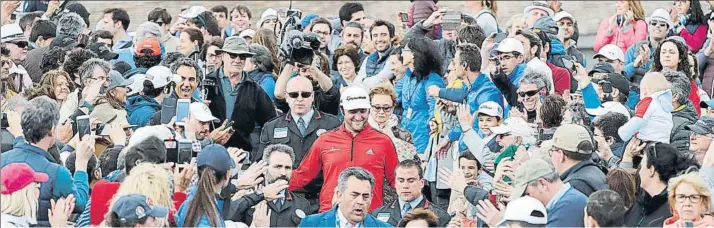  ??  ?? Cuatro imágenes para la historia. Rahm, en un pasillo de honor que le hizo el gentío que no paró de animarle; saludando en el hoyo 18; jugando el segundo golpe en el 17 tras no irse al agua, y abrazando emocionado el trofeo de campeón del Open de España