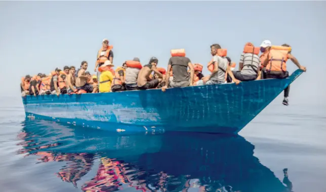  ?? Associated Press ?? Migrants from Tunisia travel aboard a wooden boat, near the Italian island of Lampedusa on Thursday.
