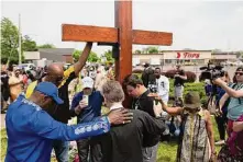  ?? Associated Press file photo ?? A group prays at a memorial outside the Tops Friendly Market in Buffalo, N.Y., for the victims of last year’s mass shooting there.