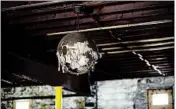  ??  ?? A mirrored disco ball hangs from the ceiling of the longshutte­red dance hall that was built by the Black Elks.
