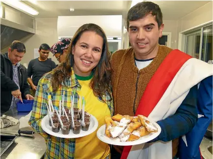  ?? JOHN HAWKINS/STUFF 634569414 ?? Katiane Viana, from Brazil, with a brigadeiro desert and Gonzalo Bascur, from Chile, with calzones rotos at the Brazilian and Chilean dinner.