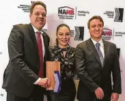  ?? Photo courtesy of Surge Homes ?? Ben Lemieux, chairman of Surge Homes, left, and Louis Conrad, president of Surge Homes, right, are congratula­ted by NAHB Awards emcee Egypt Sherrod.