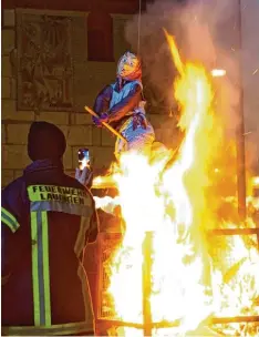  ??  ?? Die Freiwillig­e Feuerwehr passt ganz genau auf, wenn die Hexe in Lauingen verbrannt wird. Schließlic­h soll niemand verletzt werden – außer der Schwertgos­chin.