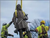  ?? JOHN C. CLARK — THE ASSOCIATED PRESS ?? Workers begin to lay the bronze statue of Confederat­e Gen. A.P. Hill onto a flatbed truck on Monday in Richmond.