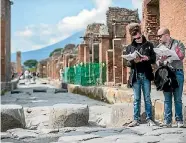  ??  ?? Tourists look at their maps as they visit Pompei, Italy.