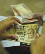  ??  ?? GAUHATI: An Indian bank official counts discontinu­ed five hundred rupees notes.