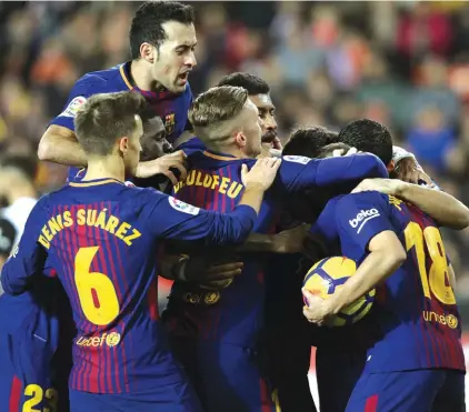  ??  ?? Barcelona players celebrate after getting a late equaliser against Valencia Photo: AP