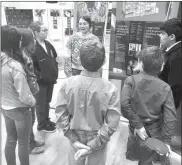  ?? Megan Helberg ?? Tenth grade students Gracie Conrad, center, and Michael Starr, right, lead other students through the Anne Frank exhibit at Loup County Public Schools.