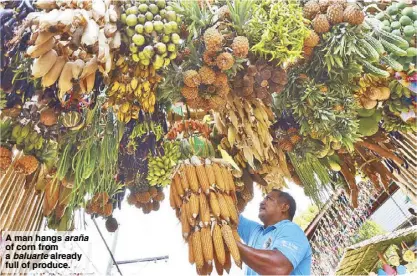  ?? ?? A man hangs araña of corn from a baluarte already full of produce.