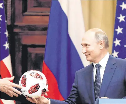  ??  ?? Politicalf­ootball: US President Donald Trump receives a football from Russian President Vladimir Putin at the now infamous meeting