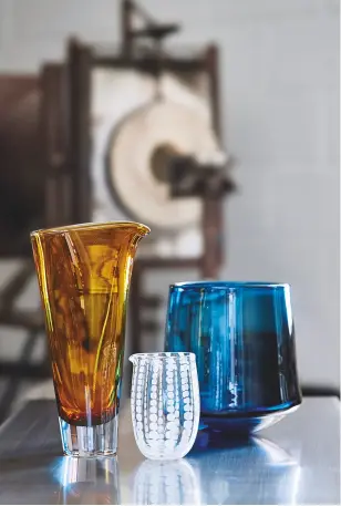  ??  ?? ABOVE The Fenland glass vase (left), £140, Fenland glass spotty jug, £60, and the Fenland vessel, £320, all made for the National Trust’s Artisan & Craft collection. BELOW LEFT Stewart holds an iron ready for Alex to attach the next piece of glass....