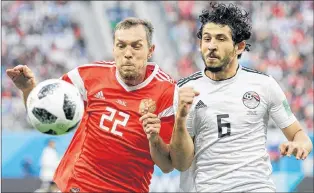  ?? AP PHOTO ?? Egypt’s Ahmed Hegazy, right, challenges for the ball against Russia’s Artyom Dzyuba during Group A action Tuesday at the 2018 soccer World Cup in St. Petersburg, Russia.