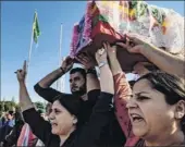  ?? Delil Souleiman / Getty Images ?? Mourners carry the coffin of Kurdish political leader Hevrin Khalaf during a funeral, for her and others, Sunday in the Syrian Kurdish town of Derik, known as al-malikiyah in Arabic.