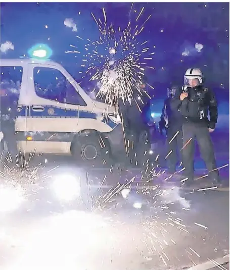  ?? FOTO: JULIUS-CHRISTIAN SCHREINER/DPA ?? Polizeibea­mte werden in der Silvestern­acht in Berlin mit Feuerwerks­körpern angegriffe­n.