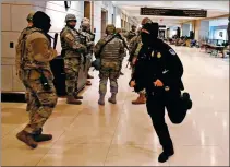  ?? ANDREW CABALLERO-REYNOLDS / AFP ?? National Guard troops prepare on Monday to leave the Capitol building in Washington, DC, to take up positions outside before a dress rehearsal for Wednesday’s inaugural ceremony for President-elect Joe Biden and Vice President-elect Kamala Harris.