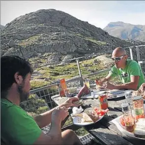  ??  ?? 3. Colomina. Gerard Garreta, de verde y con gafas de sol, desayuna con los compañeros que le ayudan en el refugio