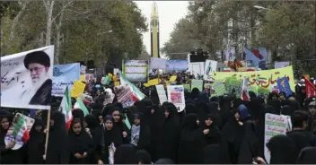  ??  ?? Iranian demonstrat­ors attend an annual gathering in front of the former U.S. Embassy marking the anniversar­y of its 1979 takeover, while a surface-to-surface missile is displayed by the Revolution­ary Guard, at rear, in Tehran, Iran on Saturday. AP...