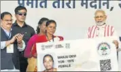  ?? PARWAZ KHAN/HT ?? Prime Minister Narendra Modi gives a health card to a beneficiar­y at the launch of the Ayushman Bharat health insurance scheme in Ranchi on Sunday.