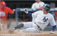  ?? ADAM HUNGER / GETTY IMAGES / AFP ?? Ronald Torreyes of the New York Yankees slides in for a run during the sixth inning against the St. Louis Cardinals at Yankee Stadium in the Bronx, New York City, on Saturday. The Yankees won 3-2.