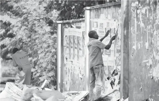  ?? PIC: GODSWILL AYEMOBA ?? Staff of Abuja Environmen­tal Protection Board (AEPB) removing posters from walls along Ahmadu Bello Way in Abuja yesterday.