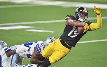  ?? Peter Diana/Post-Gazette ?? Steelers wide receiver JuJu Smith-Schuster stretches for a touchdown against the Dallas Cowboys on Nov. 8. He re-signed with the Steelers for one more year, the team said Friday.
